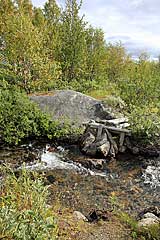 Reste einer Holzbrücke am Fluss vom See Skáŋgalanjávri 