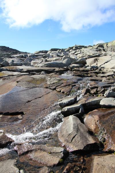 Ein Fluss fliesst über die Felsenplatten