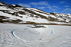 Schneefeld mit Wasserlauf